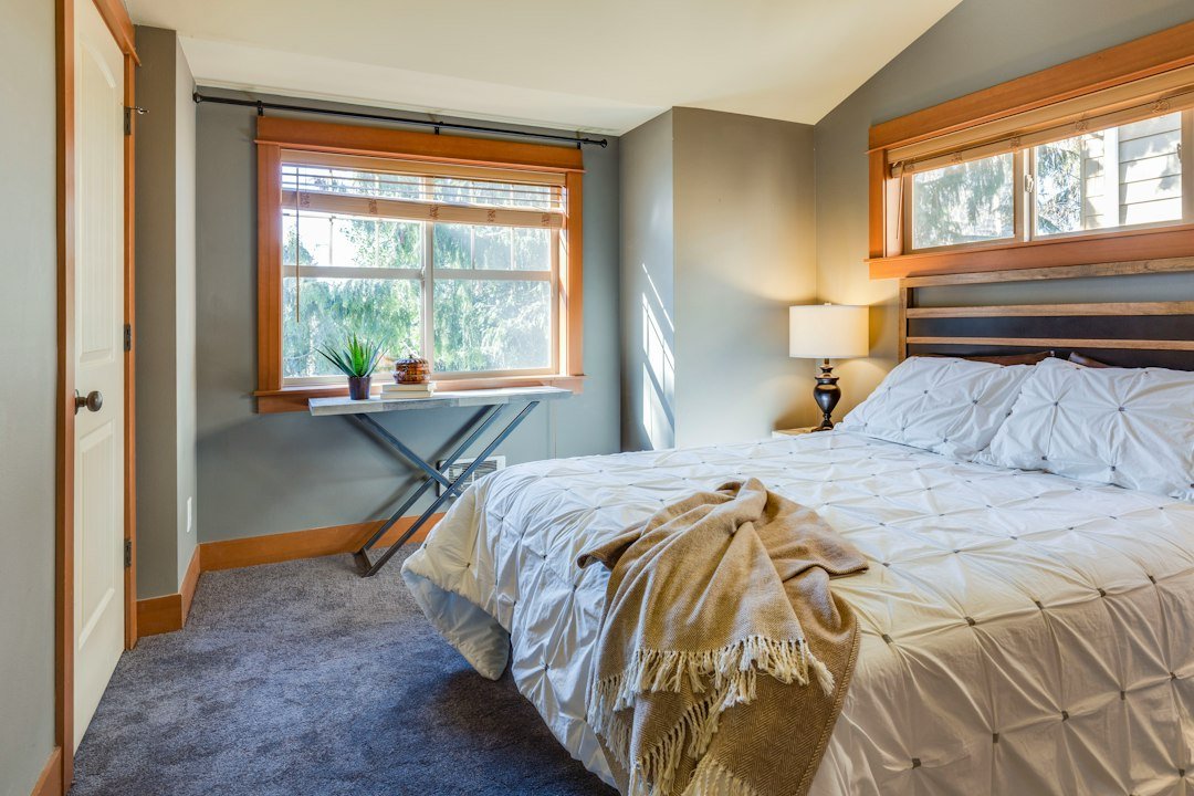 Cama con ropa de cama clara para ilustrar el lavado y cuidado de sábanas de invierno