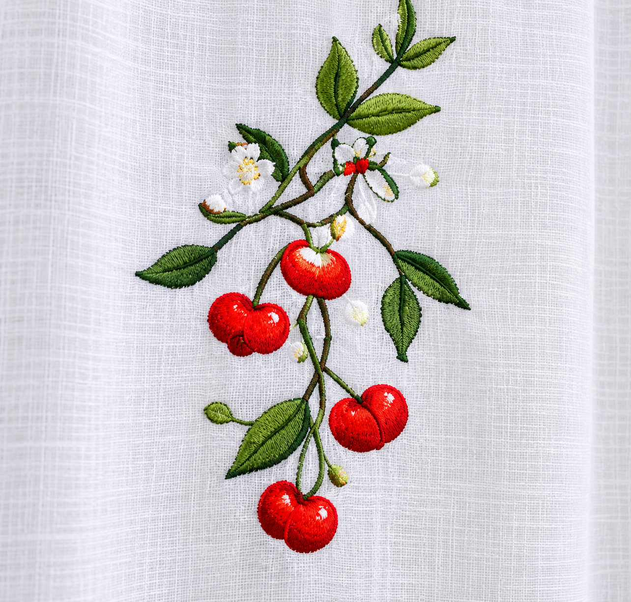 Detalle del bordado de cerezas rojas y hojas verdes